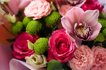 Bright pink flowers bouquet closeup. Roses and orchids wallpaper. Beautiful background for a Birthday, International Female Day, or Saint Valentine. The festive backdrop for a postcard design