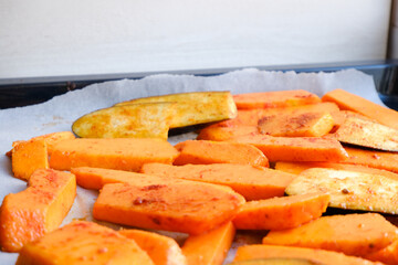 Grilled vegetables baked in the oven. Pieces of pumpkin, eggplant, Aubergine and zucchini on parchment on a baking sheet. Healthy vegan organic meal. Superfood and health care. Immune system support.