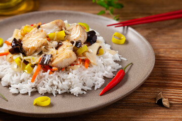 Chinese style cod, served on a plate with white rice.