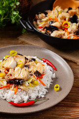 Chinese style cod, served on a plate with white rice.