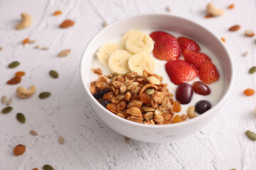 bowl of granola cereal with yogurt and berries isolated on white background