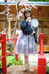Naklejka premium Beautiful young woman with dark blue Chinese lolita dress with Chinese garden