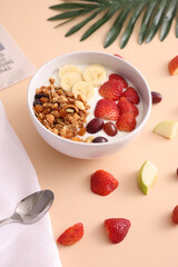 bowl of granola cereal with yogurt and berries isolated on eggnog color background