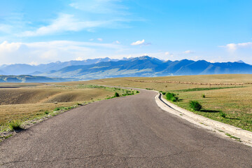 Country road and mountain nature scenery under blue sky