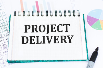 PROJECT DELIVERY text on white paper from a notepad
