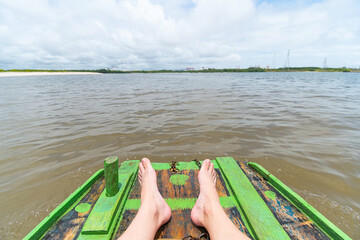 Raft ride at the mouth of the river where the water of the Ipojuca River meets the sea water in the region of Camboa beach, Ipojuca - PE, Brazil. Focus on feet.