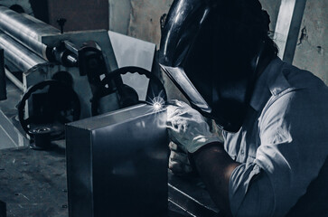 Laser welding process close up. A worker in protective clothing welds metal with a laser.
