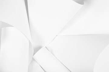 White sheets of office paper are twisted and scattered. Paper white abstract background.