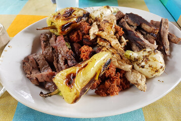 Grill with beef, chorizo and chicken accompanied with a roasted chili