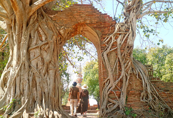 Couple Entering the Gate of Wat Phra Ngam Temple Ruins Also Known As GATE OF TIME, Ayutthaya, Thailand - obrazy, fototapety, plakaty