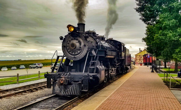 A Restored Steam Engine Getting Ready for Service, Blowing Smoke and Steam on a Cloudy Summer Day © Greg Kelton