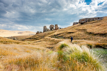 Lesotho pictures. A view of boulders and a lone walker on a trail in Sethabathebe National Park