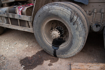 Fototapeta na wymiar Wheel hub oil leak. Wheel repair on a truck on the road. Broken car