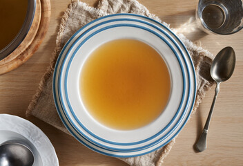 Bone broth in a white and blue plate