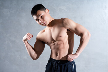 Obraz premium Muscular Asian man posing on gray background