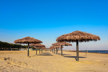 Umbrella from the sun with a roof of palm leaves on a background of the sea on a sunny day.