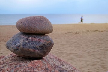 Fototapeta na wymiar Two stacked natural rocks on a sandy beach