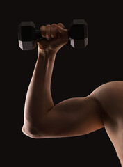 Fototapeta na wymiar man holding a dumbbell in his hand on a black background
