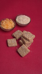 Indian makar sankranti festival food or sweets. Tilgul in a small bowl. Tilgul is made out of sesame seeds, peanuts, and jaggery. Til gud chikki or sesame candy. Copy Space.