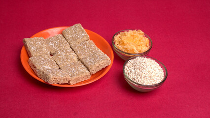 Indian makar sankranti festival food or sweets. Tilgul in a small bowl. Tilgul is made out of sesame seeds, peanuts, and jaggery. Til gud chikki or sesame candy. Copy Space.