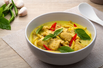Green curry chicken breast and preserved bamboo shoots in white bowl