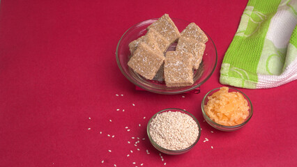 Indian makar sankranti festival food or sweets. Tilgul in a small bowl. Tilgul is made out of sesame seeds, peanuts, and jaggery. Til gud chikki or sesame candy. Copy Space.