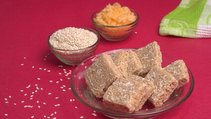 Indian makar sankranti festival food or sweets. Tilgul in a small bowl. Tilgul is made out of sesame seeds, peanuts, and jaggery. Til gud chikki or sesame candy. Copy Space.