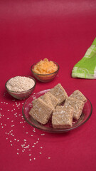 Indian makar sankranti festival food or sweets. Tilgul in a small bowl. Tilgul is made out of sesame seeds, peanuts, and jaggery. Til gud chikki or sesame candy. Copy Space.