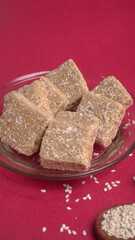Indian makar sankranti festival food or sweets. Tilgul in a small bowl. Tilgul is made out of sesame seeds, peanuts, and jaggery. Til gud chikki or sesame candy. Copy Space.