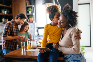 Happy multiethnic family having fun while cooking and using digital tablet at home