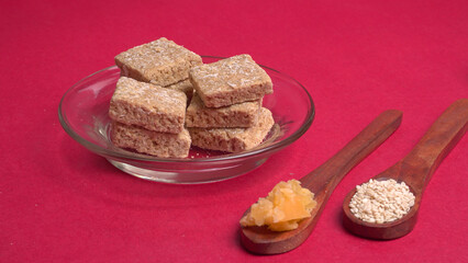 Indian makar sankranti festival food or sweets. Tilgul in a small bowl. Tilgul is made out of sesame seeds, peanuts, and jaggery. Til gud chikki or sesame candy. Copy Space.