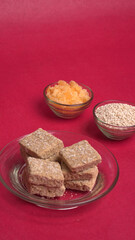 Indian makar sankranti festival food or sweets. Tilgul in a small bowl. Tilgul is made out of sesame seeds, peanuts, and jaggery. Til gud chikki or sesame candy. Copy Space.