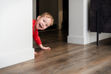 Child, toddler, little boy playing hide and seek at home. Joy at home, cozy heated floor. Creative...