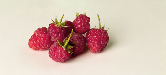 Close-up of garden raspberries on a light background.
