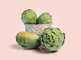 Obraz premium Fresh artichokes isolated on the pink background