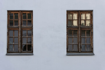 Wall of an old plastered white house with antique vintage wooden windows
