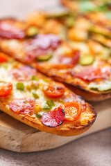 Slices of Pizza on bread with cheese and ingredients such as salami, prosciutto, ham. Selective focus