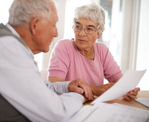 Taking time to discuss important matters. Shot of two elderly people discussing a document.