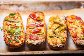 Pizza on bread with cheese and ingredients such as salami, prosciutto, ham. Close up shot