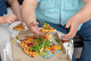 Two people divide pieces of pizza between them.