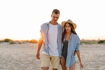 Back rear view young happy couple two friends family man woman in white shirt clothes hold hands...