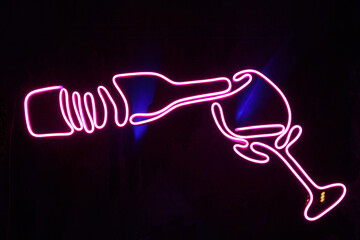 neon glowing signboard drawing in the shape of a bottle and a glass of wine
