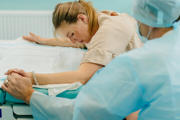 Mother giving birth to baby. Pregnant patient in a hospital. Woman in labor in delivery room,...