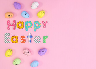 Happy Easter background with colorful eggs and text on pastel pink theme. Creative holidays greeting card with copy space. Flat lay