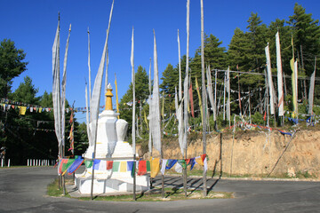 stupa, buddhist banners and prayer flags in bhutan 