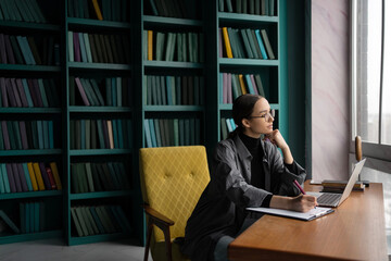 Female designer with glasses company report working in office using laptop computer, student online...