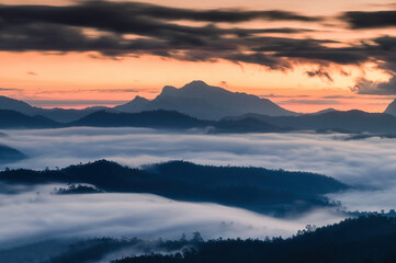 Fototapeta na wymiar Sunrise over mountain range and sea of fog flowing on hill in national park
