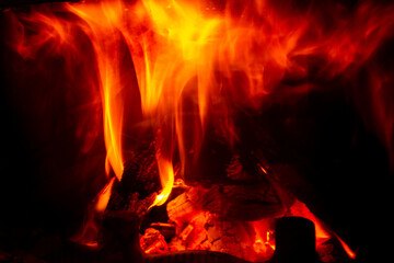 Burning wood in a home fireplace, red flames