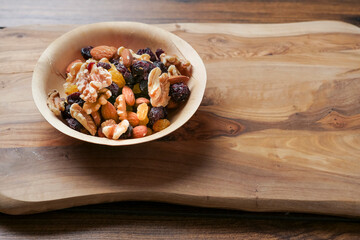 Mix fruit and nut mix in a small wooden cup. Healthy choice for energy. Raisins, walnut, almond in a bowl. Nature product