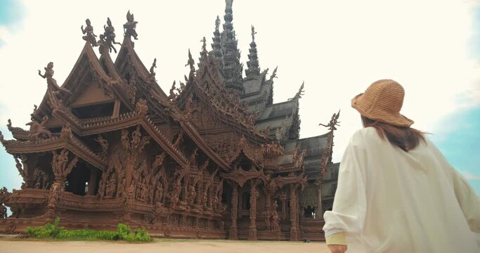 Sanctuary of Truth (Prasat Sut Ja-Tum), Rear view of woman 
tourist at beautiful Thai wooden temple interior in Pattaya Thailand, Amazing Thailand travel concept.
